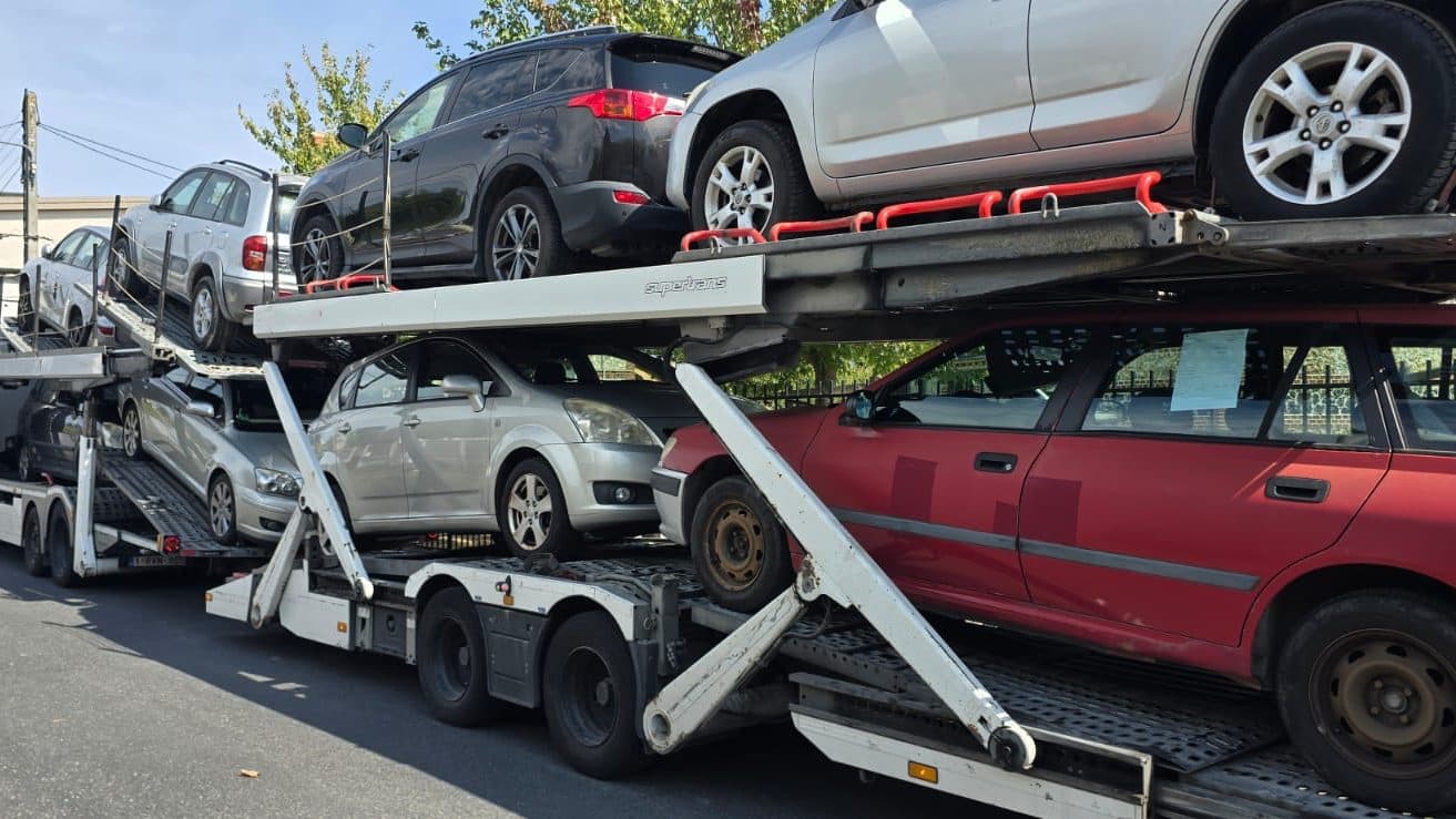 Two-tier car carrier truck loaded with sedans and 4x4s